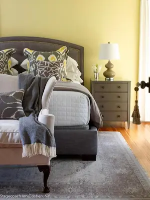 a bedroom with a bed and a dresser with a lamp at Stagecoach Inn in Goshen
