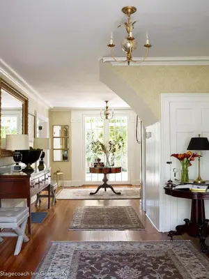 a living room with a staircase and a table at Stagecoach Inn in Goshen