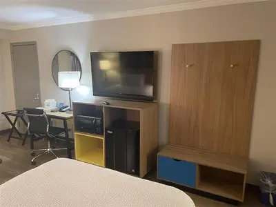 a room with a bedroom with a television and a desk at Days Inn by Wyndham Wilmington Brandywine in Talleyville