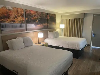 a hotel room with two beds and two lamps at Days Inn by Wyndham Wilmington Brandywine in Talleyville