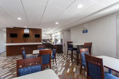 a dining room with tables and chairs and a bar at Days Inn by Wyndham Wilmington Brandywine in Talleyville