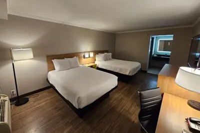 a hotel room with two beds and a desk at Days Inn by Wyndham Wilmington Brandywine in Talleyville