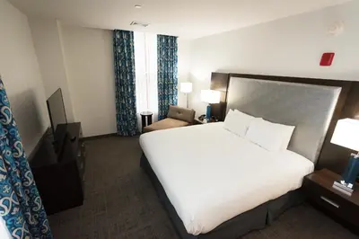 a hotel room with a large white bed and a chair at Hilton Scranton & Conference Center in Scranton