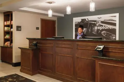 a man is standing behind a reception desk at Hampton Inn Reading/Wyomissing in Wyomissing