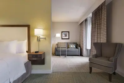 a hotel room with a bed and a chair at Hampton Inn Reading/Wyomissing in Wyomissing
