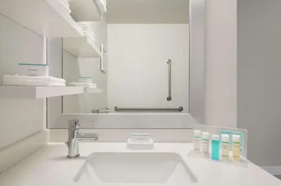 a white bathroom with a sink and a mirror at Hampton Inn Reading/Wyomissing in Wyomissing