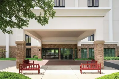 two red benches in front of a building at Hampton Inn Reading/Wyomissing in Wyomissing