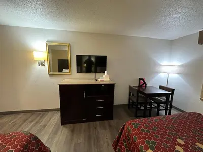 a hotel room with a bed and a desk with a mirror at Econo Lodge Scranton near Montage Mountain in Scranton