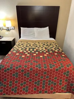 a bed in a hotel room with a colorful bedspread at Econo Lodge Scranton near Montage Mountain in Scranton