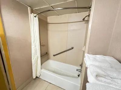 a bathroom with a tub and a shower with towels at Econo Lodge Scranton near Montage Mountain in Scranton