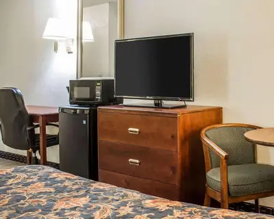 a hotel room with a television on a dresser with a bed at Econo Lodge Scranton near Montage Mountain in Scranton
