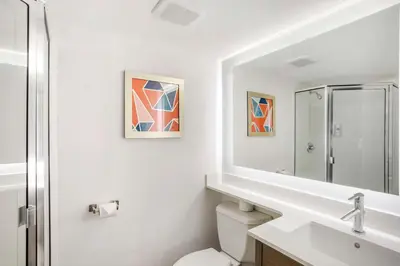 a bathroom with a toilet and a sink and a mirror at Comfort Inn Edgewater on Hudson River in Edgewater