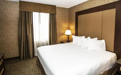 a large white bed in a hotel room with a window at Heritage Hills Golf Resort & Conference Center in York