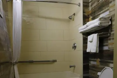 a bathroom with a shower and a toilet and towels at TraveIodge by Wyndham Parsippany in Parsippany