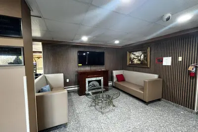 a lobby with two chairs and a table and a tv at TraveIodge by Wyndham Parsippany in Parsippany