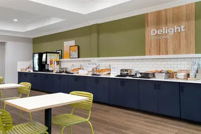 a kitchen with blue cabinets and a table and chairs at Spark by Hilton Rahway in Rahway