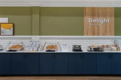 a kitchen with blue cabinets and food on a counter at Spark by Hilton Rahway in Rahway