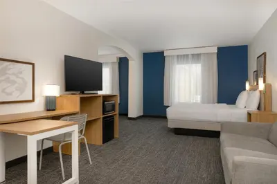 a hotel room with a bed and a tv and a couch at Spark by Hilton Rahway in Rahway