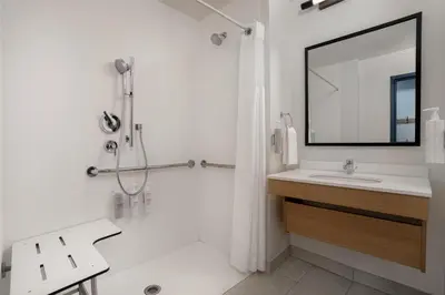 a bathroom with a sink and a shower with a mirror at Spark by Hilton Rahway in Rahway