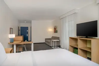 a hotel room with a bed and a flat screen tv at Spark by Hilton Rahway in Rahway