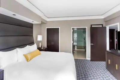 a bedroom with a large white bed with a black headboard at Hilton Club New York in New York