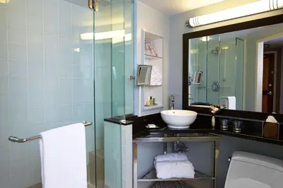 a bathroom with a sink and a glass shower at Hilton Club New York in New York