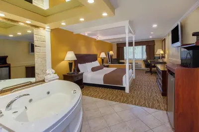 a hotel room with a bed and a bath tub at Baymont by Wyndham Pompton Plains/Wayne in Pompton Plains
