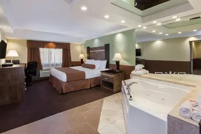 a hotel room with a bed and a bath tub at Baymont by Wyndham Pompton Plains/Wayne in Pompton Plains