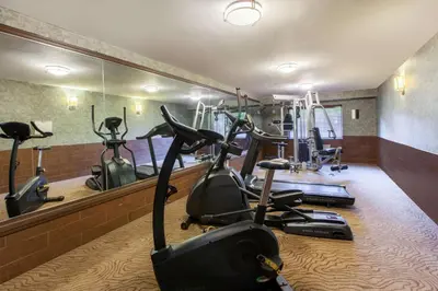 a gym with several exercise bikes in front of a mirror at Baymont by Wyndham Pompton Plains/Wayne in Pompton Plains