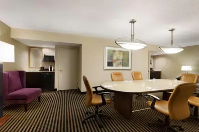 a room with a table and chairs and a kitchen at Embassy Suites by Hilton Piscataway Somerset in Piscataway