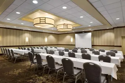 a conference room with tables and chairs and a whiteboard at Embassy Suites by Hilton Piscataway Somerset in Piscataway