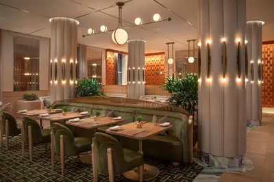 a dining room with tables and chairs and columns at Waldorf Astoria New York in New York