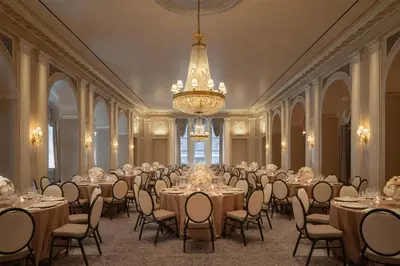 a banquet hall with tables and chairs and a chandelier at Waldorf Astoria New York in New York