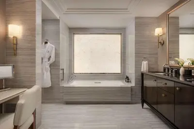a bathroom with a bath tub and a window at Waldorf Astoria New York in New York