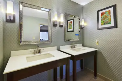 a bathroom with two sinks and two mirrors at Hampton Inn Clinton in Clinton