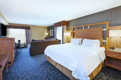 a hotel room with a large bed and a couch at Hampton Inn Clinton in Clinton