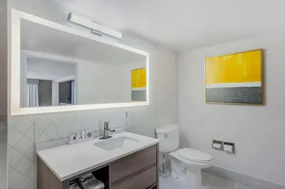 a bathroom with a sink and a toilet and a mirror at Comfort Inn & Suites Voorhees-Mt Laurel in Voorhees