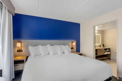 a bedroom with a large white bed with a blue wall at Comfort Inn & Suites Voorhees-Mt Laurel in Voorhees