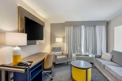 a hotel room with a desk and a living room at Comfort Inn & Suites Voorhees-Mt Laurel in Voorhees