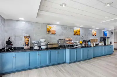 a buffet line in a restaurant with blue cabinets at Comfort Inn & Suites Voorhees-Mt Laurel in Voorhees