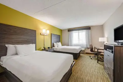 a hotel room with two beds and a flat screen tv at SureStay Plus Hotel by Best Western McGuire AFB Jackson in Cookstown
