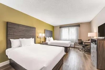 a hotel room with two beds and a desk at SureStay Plus Hotel by Best Western McGuire AFB Jackson in Cookstown