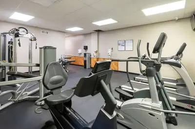 a gym with several treadmills and cardio machines at SureStay Plus Hotel by Best Western McGuire AFB Jackson in Cookstown