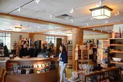 a woman standing at a counter in a store at Overlook Lodge and Stone Cottages at Bear Mountain in Highland Falls