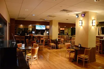 a restaurant with tables and chairs and a bar at Overlook Lodge and Stone Cottages at Bear Mountain in Highland Falls
