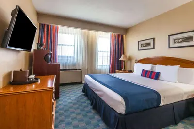 a hotel room with a bed and a flat screen tv at Ramada by Wyndham Jersey City in Jersey City