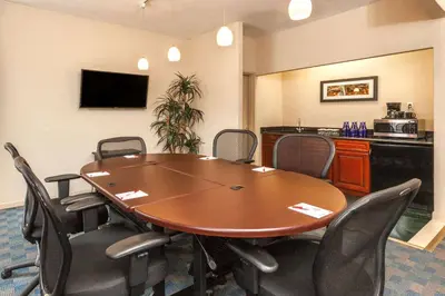 a conference room with a table and chairs at Ramada by Wyndham Jersey City in Jersey City
