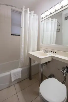 a bathroom with a sink and a toilet and a tub at Ramada by Wyndham Jersey City in Jersey City