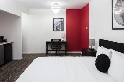 a bedroom with a white bed and a red wall at Ramada by Wyndham Jersey City in Jersey City