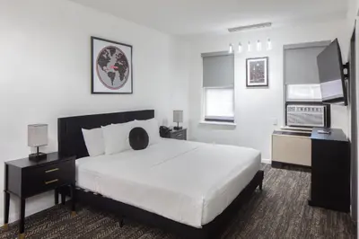 a bedroom with a large white bed with white sheets at Ramada by Wyndham Jersey City in Jersey City